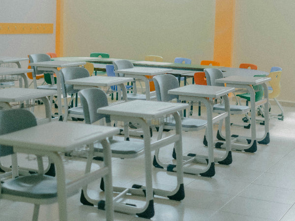 Empty classroom with rows of desks and chairs.